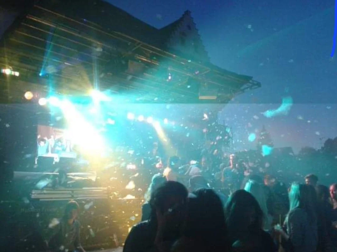 Beleuchtete Open-Air-Bühne bei Nacht mit Publikum und Konfetti