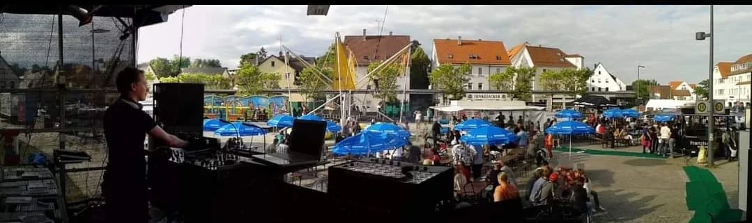 Blick vom DJ-Pult über ein Straßenfest mit Publikum und Ständen