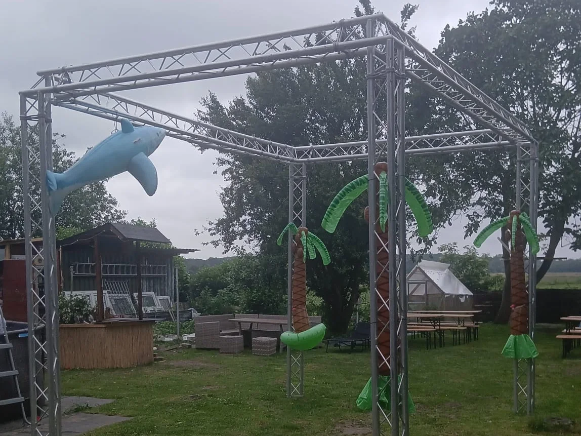Aufgebautes Traversengestell im Garten mit Palmen-Dekoration